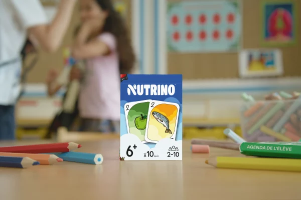 Boîte du jeu de cartes Nutrino posée sur une table, prêt à être joué