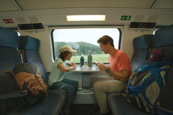 Un père et son fils jouent au jeu de cartes Nutrino dans le train, apprenant la nutrition en s'amusant