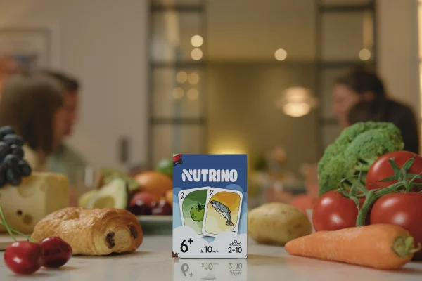Boîte du jeu de cartes Nutrino sur la table avec différentes cartes représentant des légumes